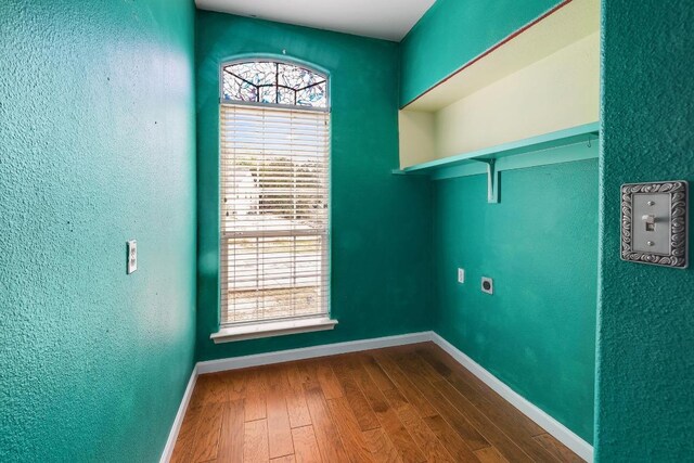 4142 Rockwood Dr, Lago Vista, TX 78645 - laundry room featuring hookup for an electric dryer, dark wood-style flooring, and a textured wall