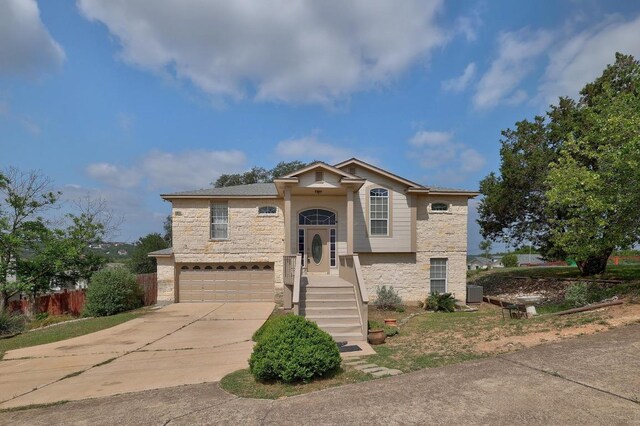 4142 Rockwood Dr, Lago Vista, TX 78645 - bi-level home with stone siding, a garage, and concrete driveway