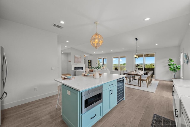 509 Flamingo Blvd, Lakeway, TX 78734 - kitchen with stainless steel appliances, wine cooler, wood finished floors, light countertops, and recessed lighting