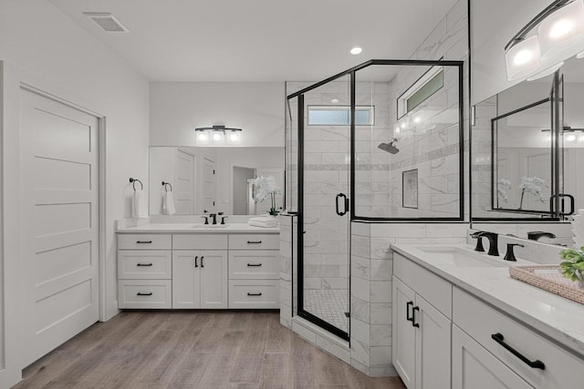 509 Flamingo Blvd, Lakeway, TX 78734 - full bathroom featuring two vanities, wood finished floors, and a stall shower