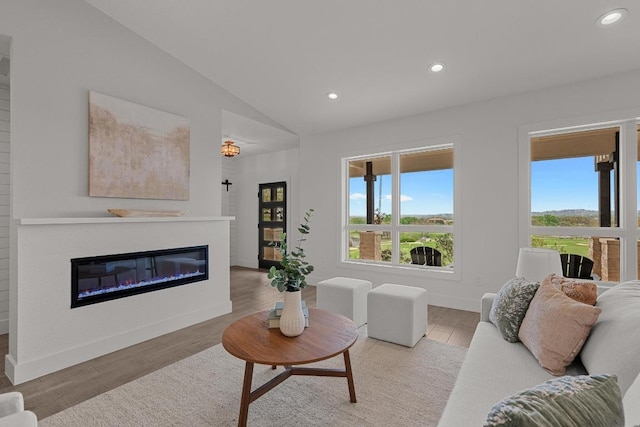 509 Flamingo Blvd, Lakeway, TX 78734 - living area featuring plenty of natural light, recessed lighting, vaulted ceiling, a glass covered fireplace, and wood finished floors