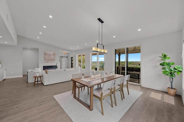 509 Flamingo Blvd, Lakeway, TX 78734 - dining room with recessed lighting, light wood finished floors, a glass covered fireplace, vaulted ceiling, and baseboards
