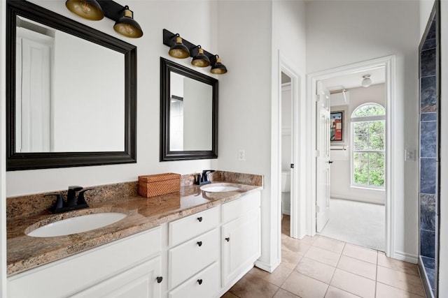 102 Hurst Creek Rd, Lakeway, TX 78734 - full bathroom with baseboards, double vanity, tile patterned floors, and toilet