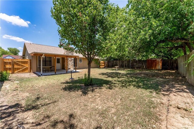 view of yard featuring a patio area and a gate
