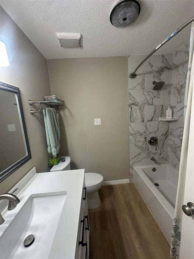full bathroom featuring a textured ceiling, wood finished floors, vanity, toilet, and shower / bath combination with curtain