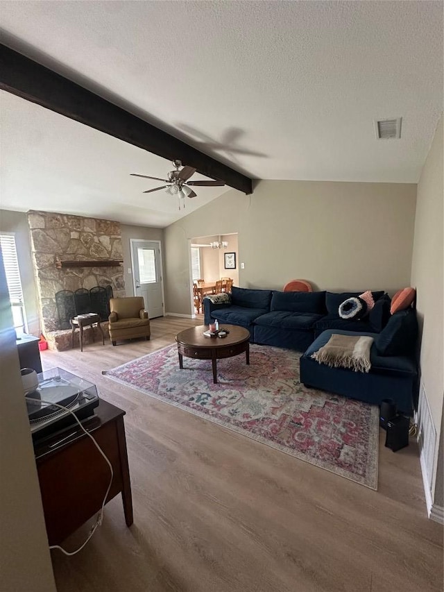 513 Purple Sage Dr, Round Rock, TX 78681 - living area featuring wood finished floors, a stone fireplace, a textured ceiling, and ceiling fan