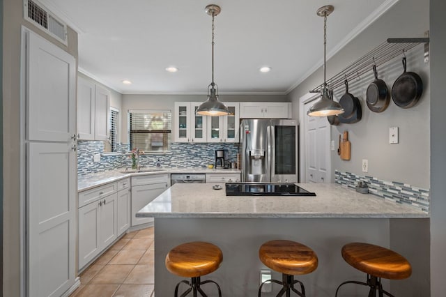 1135 Barton Hills Dr Unit 136, Austin, TX 78704 - kitchen with stainless steel appliances, tasteful backsplash, a peninsula, a breakfast bar, and crown molding