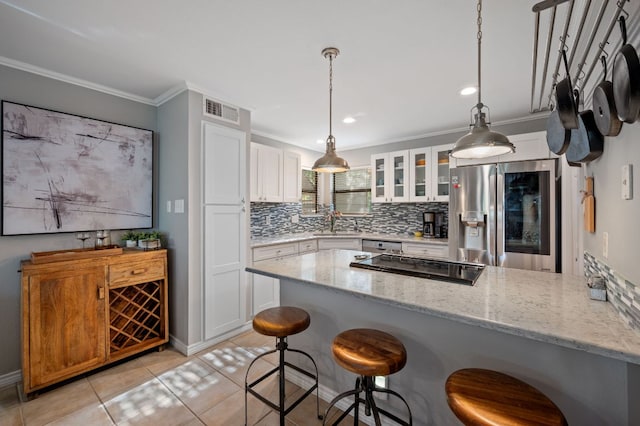 1135 Barton Hills Dr Unit 136, Austin, TX 78704 - kitchen with stainless steel refrigerator with ice dispenser, a peninsula, tasteful backsplash, a breakfast bar area, and crown molding