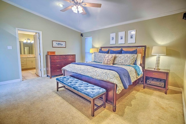 carpeted bedroom featuring lofted ceiling, ensuite bath, baseboards, ceiling fan, and ornamental molding