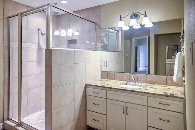 bathroom with tile walls, a stall shower, and vanity