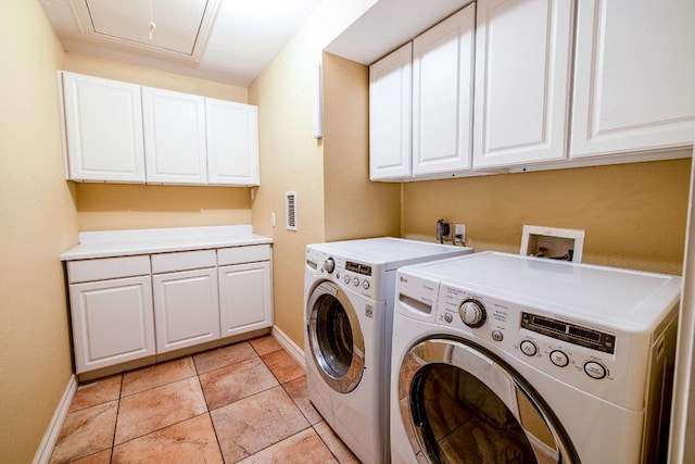 washroom featuring baseboards, attic access, cabinet space, separate washer and dryer, and light tile patterned floors
