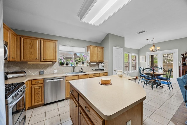 2312 Mcgregor Ln, Cedar Park, TX 78613 - kitchen featuring stainless steel appliances, a sink, lofted ceiling, tasteful backsplash, and light countertops