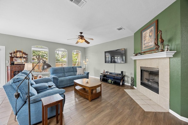 2312 Mcgregor Ln, Cedar Park, TX 78613 - living room featuring ceiling fan, a tiled fireplace, wood finished floors, and baseboards
