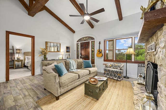 200 Oak Grove Dr, Dripping Springs, TX 78620 - living room with high vaulted ceiling, ceiling fan, a stone fireplace, wood finished floors, and beam ceiling