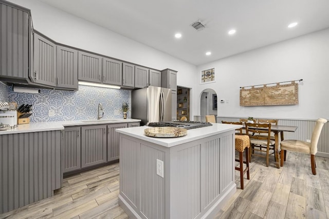 200 Oak Grove Dr, Dripping Springs, TX 78620 - kitchen featuring arched walkways, visible vents, appliances with stainless steel finishes, a sink, and gray cabinetry