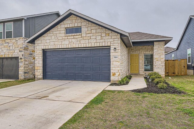 344 The Bad Way, Jarrell, TX 76537 - view of front of home featuring stone siding, a garage, and concrete driveway