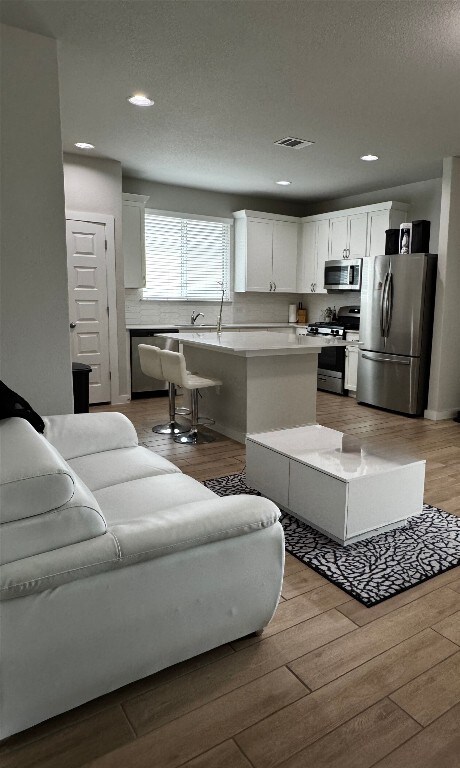 131 Harvest Ridge Blvd, Elgin, TX 78621 - living room featuring wood finished floors and recessed lighting