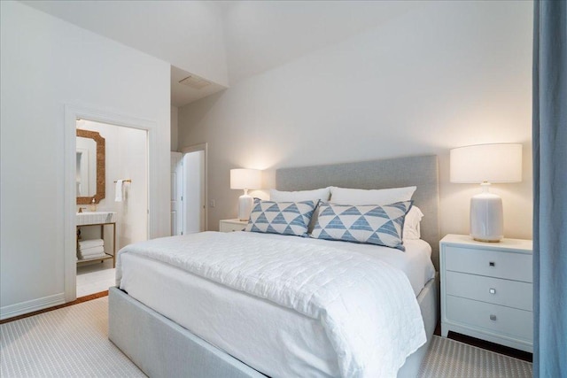 24729 Travis Lakeside Cv, Spicewood, TX 78669 - bedroom with light colored carpet and connected bathroom