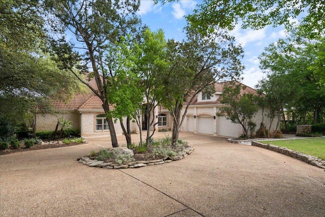 24729 Travis Lakeside Cv, Spicewood, TX 78669 - view of front of house with concrete driveway, stucco siding, and a tiled roof