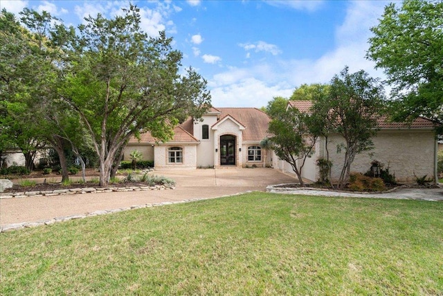 24729 Travis Lakeside Cv, Spicewood, TX 78669 - view of front facade with a tile roof, concrete driveway, a front yard, and stucco siding