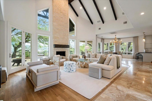 24729 Travis Lakeside Cv, Spicewood, TX 78669 - living room featuring high vaulted ceiling, beamed ceiling, a chandelier, a fireplace, and recessed lighting