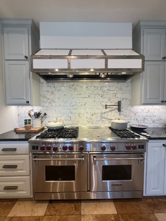 24729 Travis Lakeside Cv, Spicewood, TX 78669 - kitchen featuring double oven range, custom range hood, dark countertops, and tasteful backsplash