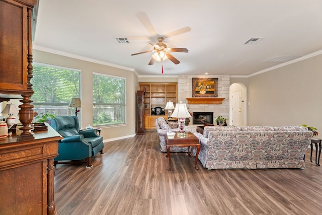 2907 Briona Wood Ln, Cedar Park, TX 78613 - living area with ceiling fan, a stone fireplace, wood finished floors, ornamental molding, and arched walkways