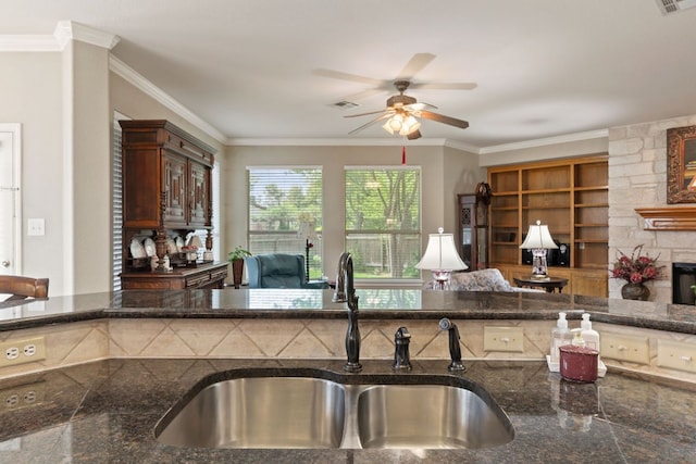 2907 Briona Wood Ln, Cedar Park, TX 78613 - kitchen with a ceiling fan, ornamental molding, dark stone countertops, open floor plan, and built in features
