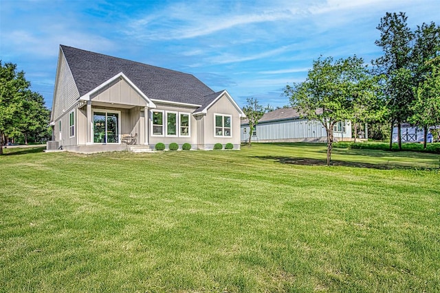 162 Puu Waa Waa Ln, Bastrop, TX 78602 - back of property featuring a lawn, board and batten siding, and roof with shingles
