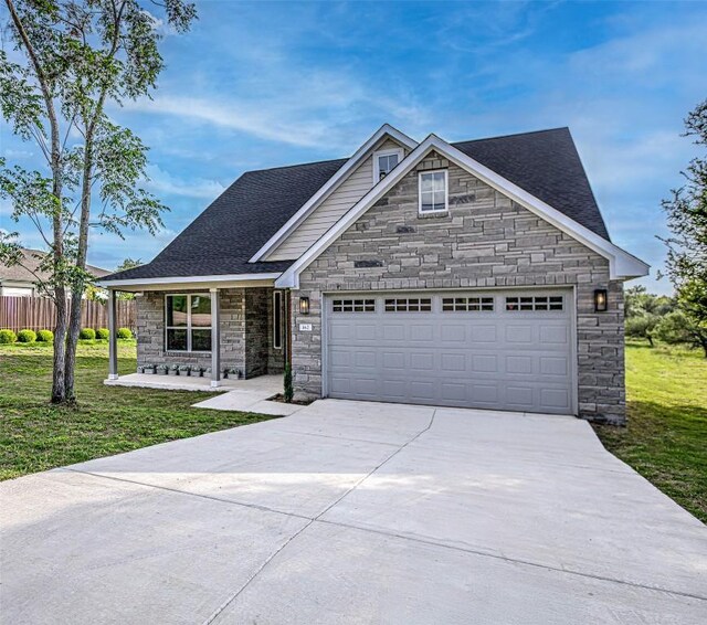162 Puu Waa Waa Ln, Bastrop, TX 78602 - view of front facade featuring stone siding, driveway, an attached garage, and roof with shingles
