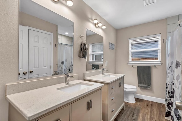 1701 Davis St, Taylor, TX 76574 - bathroom with vanity, wood finished floors, plenty of natural light, and a shower with curtain