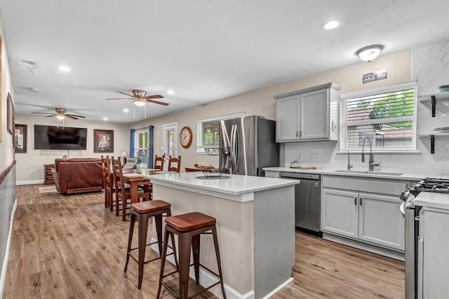1701 Davis St, Taylor, TX 76574 - kitchen with stainless steel appliances, a sink, gray cabinetry, light countertops, and recessed lighting
