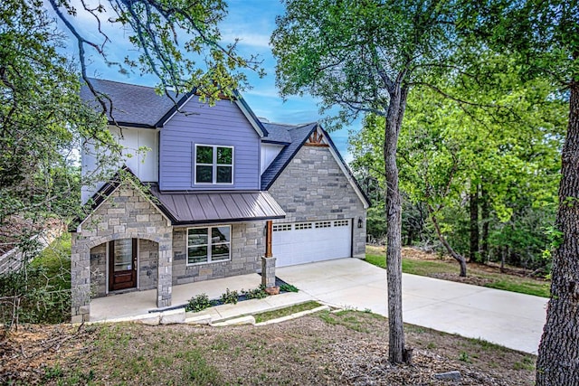 view of front of house with stone siding, a garage, a porch, concrete driveway, and a standing seam roof