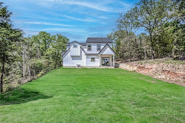 view of front of home featuring board and batten siding, central AC, french doors, and a front yard