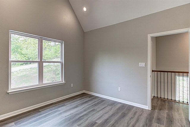 spare room featuring baseboards, recessed lighting, wood finished floors, and lofted ceiling