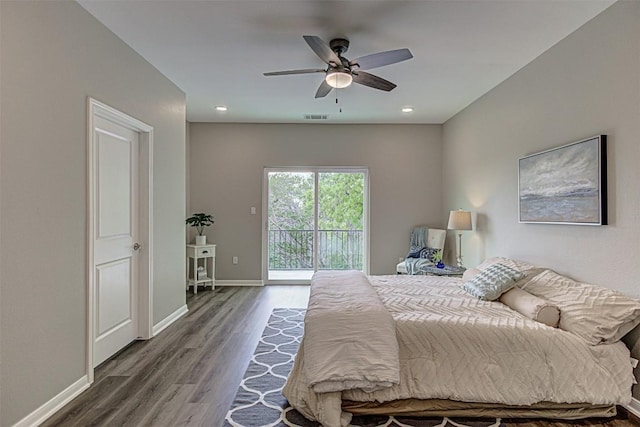 bedroom with baseboards, access to outside, wood finished floors, and visible vents