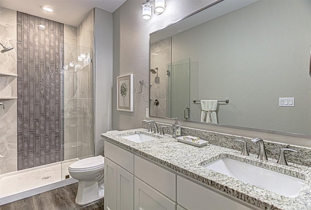 bathroom featuring a sink, wood finished floors, and a shower stall