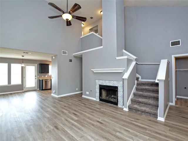 118 Dogwood Dr, Georgetown, TX 78626 - unfurnished living room featuring visible vents, wood finished floors, ceiling fan, and a tile fireplace
