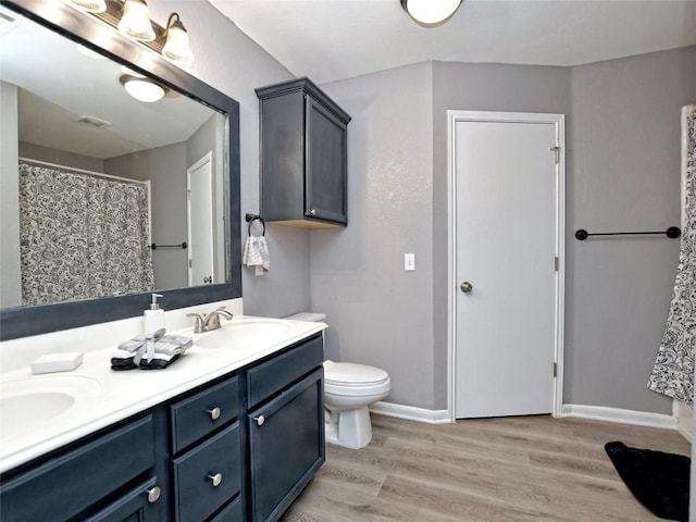 118 Dogwood Dr, Georgetown, TX 78626 - full bathroom featuring toilet, a sink, wood finished floors, baseboards, and double vanity