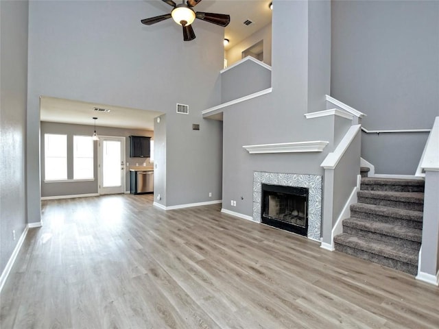 118 Dogwood Dr, Georgetown, TX 78626 - unfurnished living room with visible vents, light wood-style floors, ceiling fan, and a fireplace