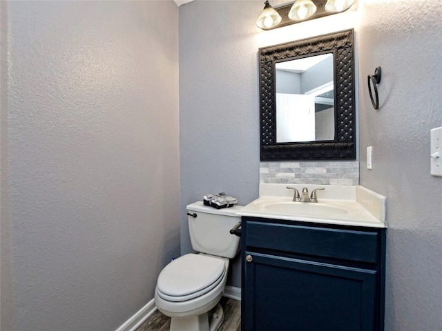 118 Dogwood Dr, Georgetown, TX 78626 - bathroom with vanity, toilet, a textured wall, baseboards, and wood finished floors