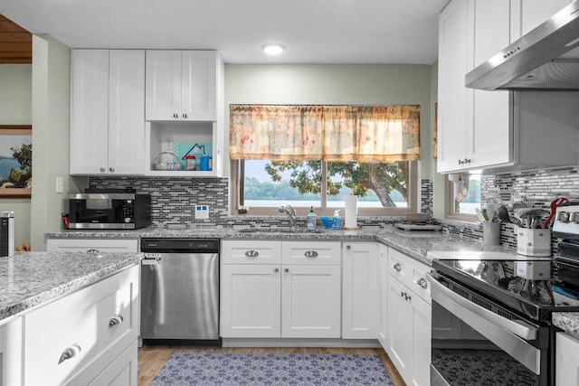 932 Scenic Loop, Kingsland, TX 78639 - kitchen with appliances with stainless steel finishes, exhaust hood, decorative backsplash, and light stone counters