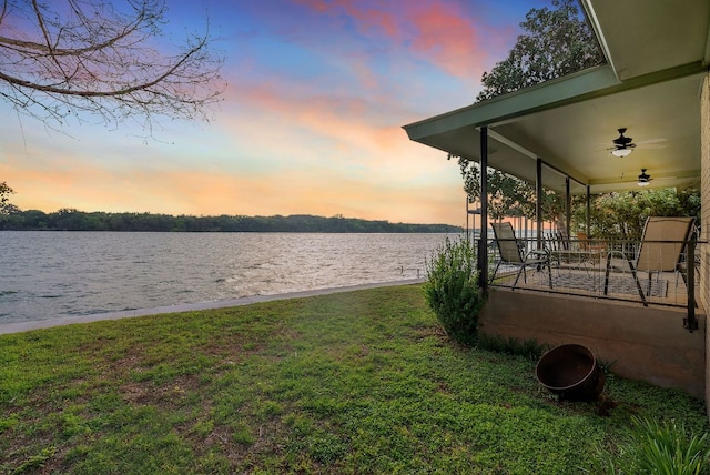 932 Scenic Loop, Kingsland, TX 78639 - yard at dusk with a water view, a lawn, and a ceiling fan