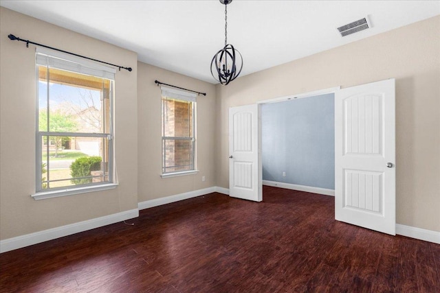 100 Matthews, Kyle, TX 78640 - unfurnished room with a chandelier, baseboards, wood finished floors, and healthy amount of natural light