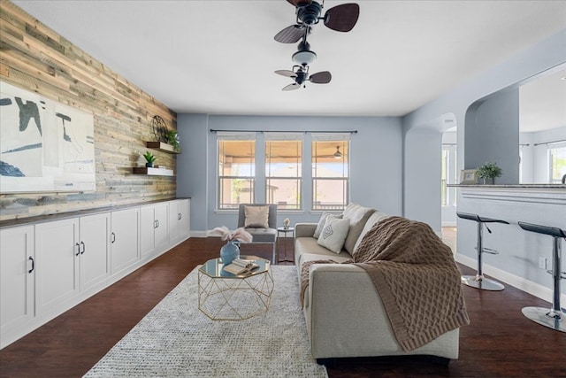 100 Matthews, Kyle, TX 78640 - living room with ceiling fan, dark wood-style floors, arched walkways, and baseboards