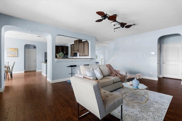 100 Matthews, Kyle, TX 78640 - living room featuring arched walkways, a ceiling fan, dark wood-style floors, and baseboards