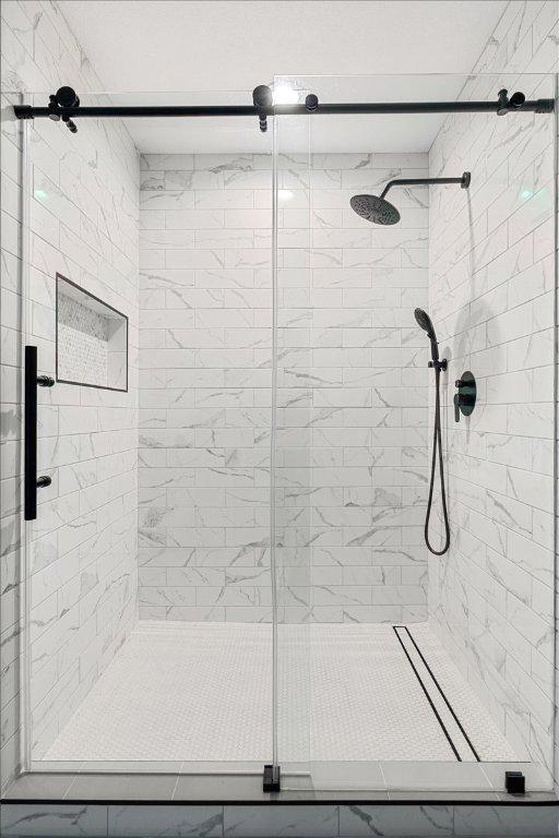 100 Matthews, Kyle, TX 78640 - bathroom with a stall shower and marble look tiles