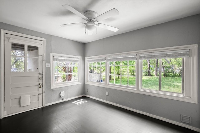 7202 Marcell St, Austin, TX 78752 - entrance foyer with plenty of natural light, a ceiling fan, a textured wall, and dark wood-type flooring