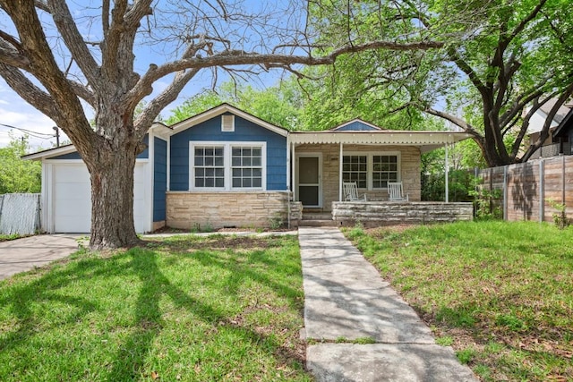 7202 Marcell St, Austin, TX 78752 - view of front of house with stone siding, a porch, an attached garage, and driveway
