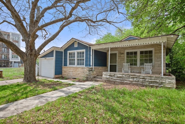 7202 Marcell St, Austin, TX 78752 - single story home with covered porch, stone siding, a garage, a front yard, and driveway